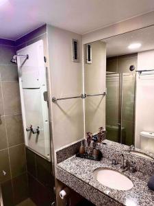 里約熱內盧的住宿－Apartamento Rio de Janeiro，浴室配有盥洗盆和带镜子的淋浴