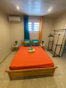 a bedroom with a large orange bed in a room at L'OCEAN BLEU DES ANSES in Quartier du Fond Fleuri