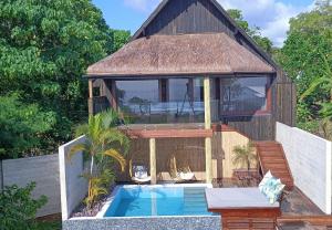 a villa with a swimming pool and a house at Bombua Beach House in Luganville