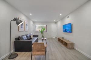 a living room with a couch and a tv on a wall at Steps Away from Calle Ocho in Little Havana in Miami