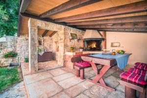 eine Außenküche mit einem Tisch und einem Backofen in der Unterkunft Villa Dina sa bazenom in Marčana