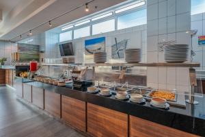 a large kitchen with a buffet line with food at La Venta Inn Ciudad del Carmen in Ciudad del Carmen