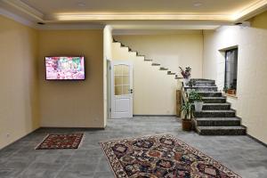 a hallway with stairs and a tv on the wall at woolway studios in Argavand