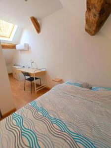 a bedroom with a bed and a desk and a table at Agréable maison 8 personnes WIFI et clim in Marmeaux