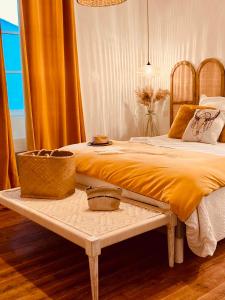 ein Schlafzimmer mit einem großen Bett und einem Tisch davor in der Unterkunft Maison 15 in Sauternes