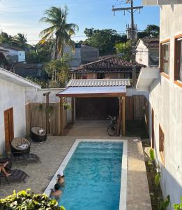 two people in a swimming pool in a house at Residência Vittoria - Apartamento aconchegante em condomínio no centro de Arraial d Ajuda in Porto Seguro