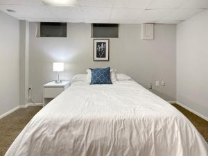 德梅因的住宿－Family Friendly 3 Br 2 Bath Duplex Sleeps 9!，卧室配有一张白色大床和蓝色枕头