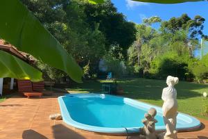 a statue standing next to a small swimming pool at Cabañas con piscina en la entrada de Oberá in Oberá