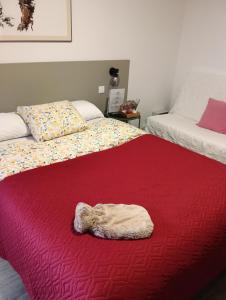 Una cama con una manta roja con una toalla. en Aveiro Ria View, en Aveiro