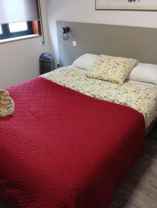 een slaapkamer met een bed met een rood dekbed bij Aveiro Ria View in Aveiro