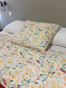 アヴェイロにあるAveiro Ria Viewの花柄の掛け布団と枕2つが備わるベッド1台
