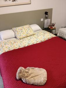 Una cama con un edredón rojo con un animal de peluche. en Aveiro Ria View, en Aveiro