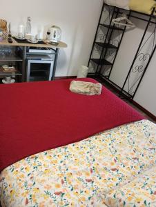 Una cama con colcha roja y una toalla. en Aveiro Ria View, en Aveiro