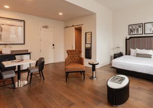 Habitación de hotel con cama, mesa y sillas en The Rubenstein Hotel, en Nueva Orleans