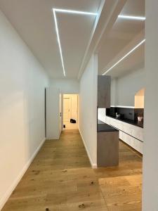 een lege keuken met witte muren en een houten vloer bij Palais Living Suite in Wenen