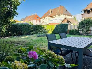 a picnic table and chairs in a garden with flowers at Bodensee-Haus IStayUnixI Seenähe-Terrasse-Garten-Netflix-Parkplatz in Radolfzell am Bodensee