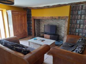 a living room with two couches and a fireplace at Gite de la croix de Fénelon in Masclat