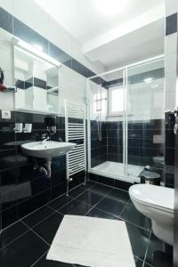 een badkamer met een wastafel, een douche en een toilet bij Fantastik Ayaz Apartments in Ohrid