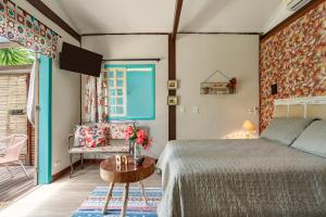 um quarto com uma cama e uma mesa em Paradise Bangalô em Florianópolis