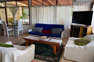 ein Wohnzimmer mit einem blauen Sofa und einem Tisch in der Unterkunft Cabañas con piscina en la entrada de Oberá in Oberá