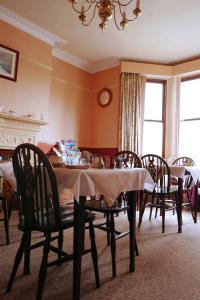 Abbey Guest House في نورويتش: غرفة طعام مع طاولة وكراسي