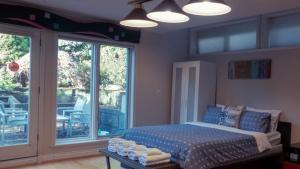 a bedroom with a bed and sliding glass doors at Van Nest near YVR UBC Downtown in Vancouver