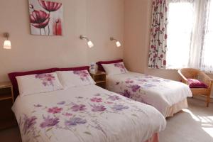 a bedroom with two beds and a window at Abbey Guest House in Norwich +10 photos