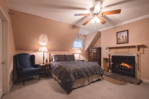 a bedroom with a bed and a chair and a fireplace at Deerfield Valley Inn - Mt Snow in Dover