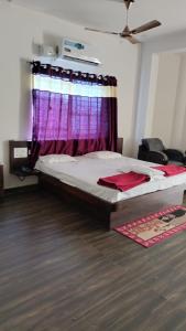 um quarto com uma cama com uma cortina roxa em Hotel Goodluck 