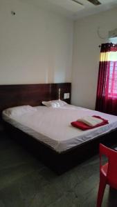 um quarto com uma cama com toalhas vermelhas em Hotel Goodluck 