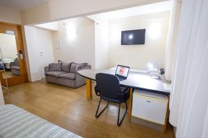 a room with a desk with a laptop on it at Sables Hotel Guarulhos in Guarulhos