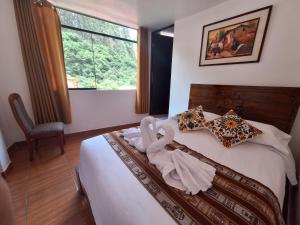 a bedroom with a bed with a towel on it at CUSI QOYLLOR in Machu Picchu