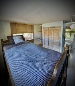 een slaapkamer met een bed met een blauw dekbed bij Cabaña frente al Lago Lanalhue in Lago Lanalhue