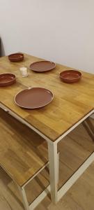 una mesa de madera con cuatro platos marrones. en Duplex lumineux & Wifi Netflix, en Roubaix