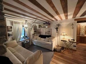 een woonkamer met een bank en een tafel bij La casetta del cuore tra terme e montagna in Pré-Saint-Didier