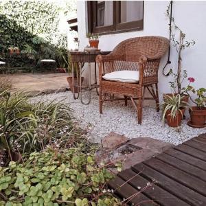 una silla de mimbre sentada junto a una ventana en un jardín en Chalet Las Nenas B&B en Mar del Plata