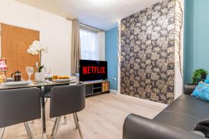 a living room with a dining table and a tv at STAYZED R - Urban Oasis NG7, Walking Distance From City Centre & Lots of Amenities - Large bedrooms, Perfect for Work, Tourism, Family and Contractors - Long Stays Welcome in Nottingham