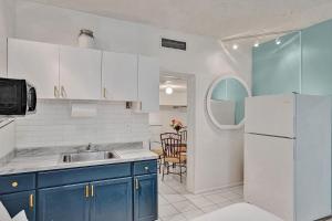 a kitchen with a sink and a refrigerator at Walk to Hallandale Beach Pool Christmas Retreat in Hallandale Beach