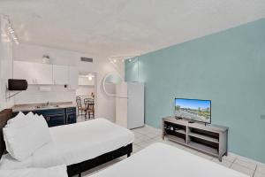 uma cozinha e uma sala de estar com uma cama e uma televisão em Walk to Hallandale Beach Pool Christmas Retreat em Hallandale Beach