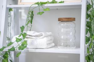 a shelf with towels and a jar of water at STAYZED R - Urban Oasis NG7, Walking Distance From City Centre & Lots of Amenities - Large bedrooms, Perfect for Work, Tourism, Family and Contractors - Long Stays Welcome in Nottingham