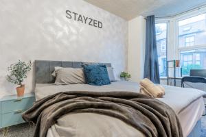 a bedroom with a bed with a blanket on it at STAYZED R - Urban Oasis NG7, Walking Distance From City Centre & Lots of Amenities - Large bedrooms, Perfect for Work, Tourism, Family and Contractors - Long Stays Welcome in Nottingham