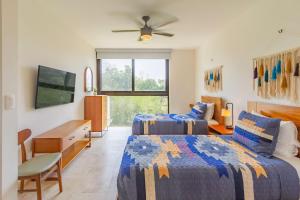 a hotel room with two beds and a tv at Tropical Retreat Pools Golf Gym Jungle Views in Akumal