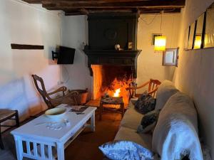 ein Wohnzimmer mit einem Sofa und einem Kamin in der Unterkunft Casa de Diego el Barbero in Benarrabá
