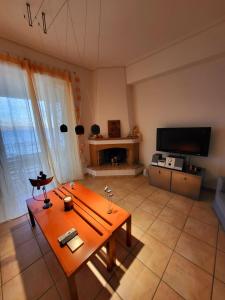 a living room with a table and a television at Dilion Guest Apartment in Dhílesi
