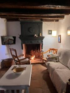 a living room with a fireplace and a couch at Casa de Diego el Barbero in Benarrabá