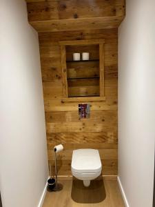 uma casa de banho com WC numa parede de madeira em Superbe appartement neuf avec Sauna privé & Terrasse vue sur la montagne em La Bresse