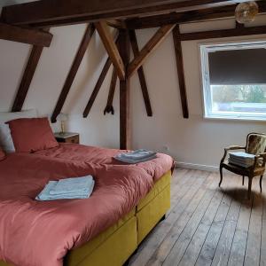 a bedroom with a bed and a window and a chair at Schlossbahnhof Ballenstedt in Ballenstedt