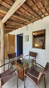 une salle à manger avec une table et des chaises en verre dans l'établissement Pousada Sol Nascente Caraíva, à Caraíva