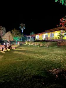 uma casa à noite com um campo de relva e um edifício em Rancho Bonanza Piri em Pirenópolis