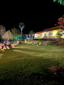 una casa por la noche con un campo de césped y un edificio en Rancho Bonanza Piri, en Pirenópolis